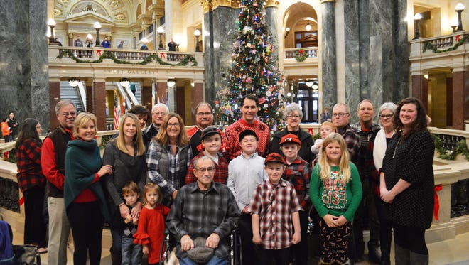 The Jim Ryf family joins Gov. Scott Walker in the rotunda on Dec. 1, where the tree donated by the family stands, honoring the 100th anniversary of the capitol building.