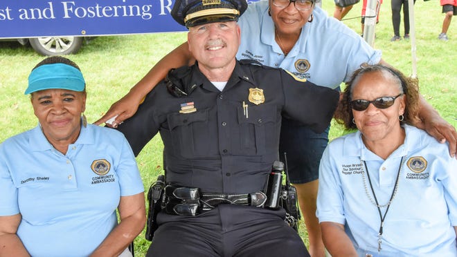 Des Moines Police Lieutenant Larry Davey poses for a photo with Community Ambassadors Dorothy Sheley (left), Vivian Bryson (left) and Corrine Jackson (back) on Saturday, June 20, 2015, during Juneteenth Observance "Neighbors Day" at Evelyn Davis Park.