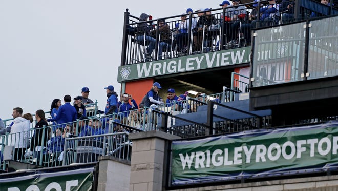 Fans sit on rooftop seats outside Wrigley Field for Game 3 of the World Series between the Cleveland Indians and the Chicago Cubs on Oct. 28, 2016.