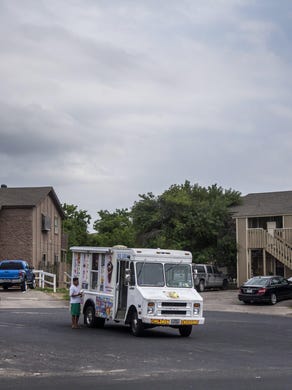 A ice cream truck idles in a northeast Austin neighborhood on Friday, May 8, 2020. The surrounding apartments house some of the students Jose Carrasco, community coordinator Austin Voices, has been trying to contact since schools have closed during the coronavirus pandemic.