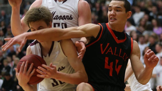 Valley's Quinton Curry reaches across the face of Dowling's Cole Scieszinski during a high school boys basketball game between Valley and Dowling Catholic on Friday, Feb. 13, 2015, at Dowling Catholic High School in West Des Moines, Iowa.