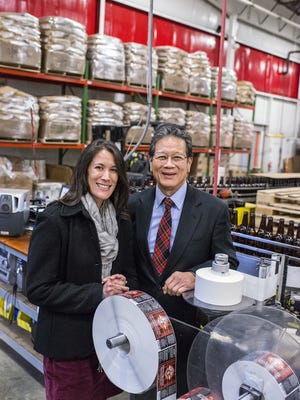 Leah Wong Ashburn, left, and Oscar Wong stand inside the bottling area at Highland Brewing as the brewery's new Devil's Britches IPA prepared to ship in the final days of 2014. Ashburn took over from her father and Highland founder Wong the following year. This year, she has secured her first James Beard nomination.