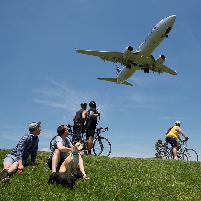 People watch planes at Gravelly Point Park, just north of the runway at Washington DC's Reagan National Airport on May 24, 2015.