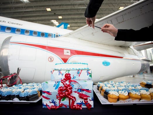 Gifts and cupcakes line a table in front of the first