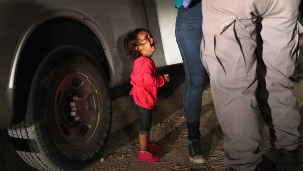A two-year-old Honduran asylum seeker cries as...