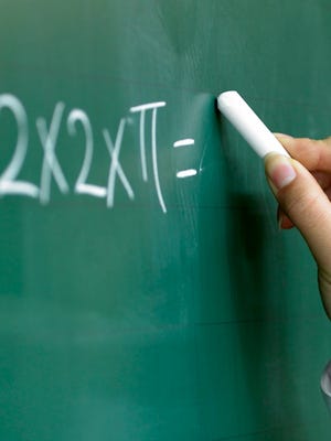 A file photo of a student writing on a chalkboard. Classes at Sparks Middle School were cancelled following an early morning power outage.