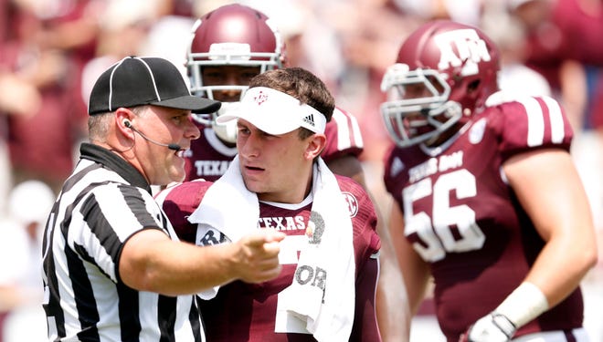 A referee yells at Texas A&M Aggies quarterback Johnny Manziel (2) to get on the sideline against the Rice Owls during the second quarter at Kyle Field.