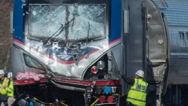 An National Transportation Safety Board staffer inspects the engine of Amtrak Train 89 which hit a construction vehicle on the tracks and derailed in Chester, Pa., Sunday, April 3, 2016. The train was heading from New York to Savannah, Ga.