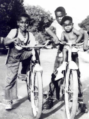 In this circa 1950 photograph taken in Summit-Argo, Illinois, Emmett Till (left) sits on a bicycle beside his cousin, Wheeler Parker (right) with his passenger, Joe Williams.