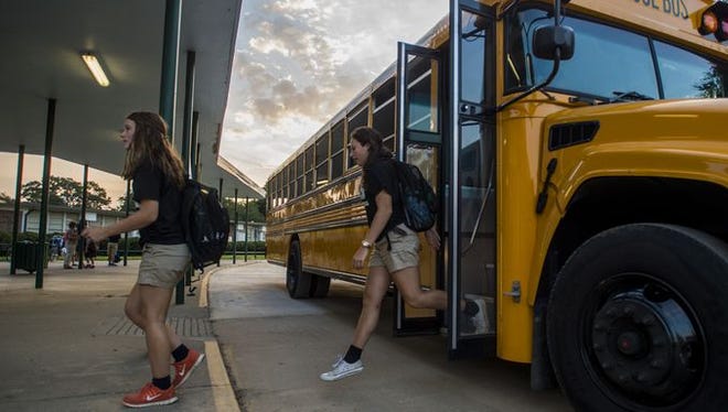 Students exit a bus on the Lafayette High campus.
