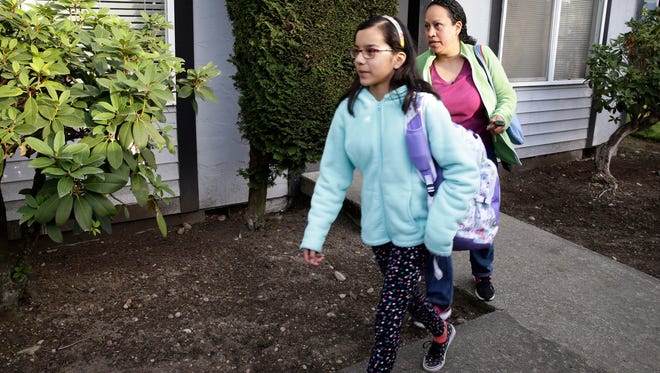 In this photo taken March 31, 2016, Teresa Garcia, right, walks with her daughter, Alondra Miranda, 11, as they leave their apartment for school in Federal Way, Wash., south of Seattle. Garcia, who has spent 14 years in the United States illegally after staying beyond the expiration of her tourist visa in 2002, is one of millions who could be affected when the political fight over immigration comes to the U.S. Supreme Court on Monday, April 18, 2016, as the court weighs the fate of Obama administration programs that could shield roughly 4 million people from deportation and grant them the legal right to hold a job.