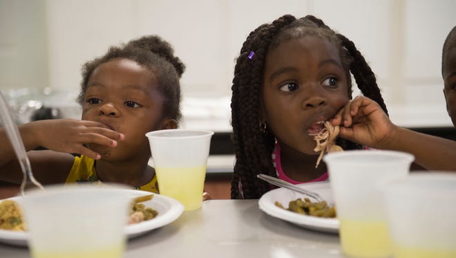 Myla Reed, 3, and Ronysha Christian, 3, both of Stuart, eat their meals during Gertrude Walden Child Care Center's annual free Thanksgiving feast on Nov. 16, 2017 at the center in Stuart. The Child Care Center's annual Spaghetti Dinner & Raffle Fundraiser is up next on Feb. 23.  Dinner will be served for $5 per person.