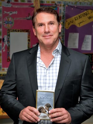 Holding a copy of his breakthrough best-selling novel, "The Notebook," is Nicholas Sparks, just prior to speaking at the Sycamore Junior High School April 13.