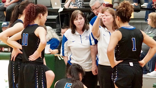Olympic coach Laurie Shaw (second from right) gives late-game instructions to the Trojans during the West Central District tournament at Foss HS in Tacoma. Shaw resigned as head coach on Monday after nine seasons.