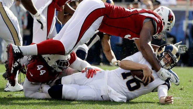 Los Angeles Rams quarterback Jared Goff, bottom right, is sacked by Arizona Cardinals outside linebacker Markus Golden (44) and defensive end Calais Campbell, top, during the first half of an NFL football game Sunday, Jan. 1, 2017, in Los Angeles.