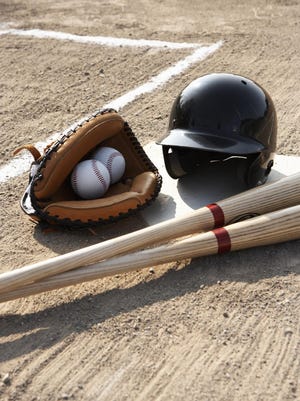 Baseball glove, balls, bats and baseball helmet at home plate