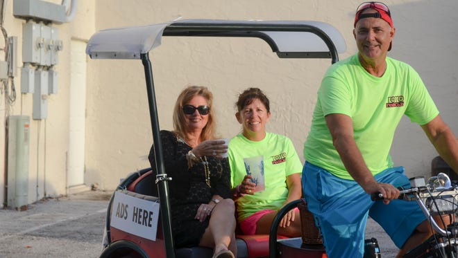 Nick Schauman driving the pedicab with Maryanne and friend Ellen Abbott in the cab.