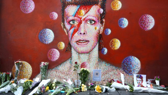 Flowers are laid beneath a mural of David Bowie in Brixton on January 11, 2016 in London, England.