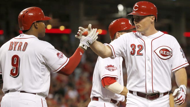 Reds right fielder Jay Bruce (right) is congratulated by left fielder Marlon Byrd after hitting a go-ahead home run in the bottom of the sixth inning to give the Reds a 5-4 lead Monday at Great American Ball Park.