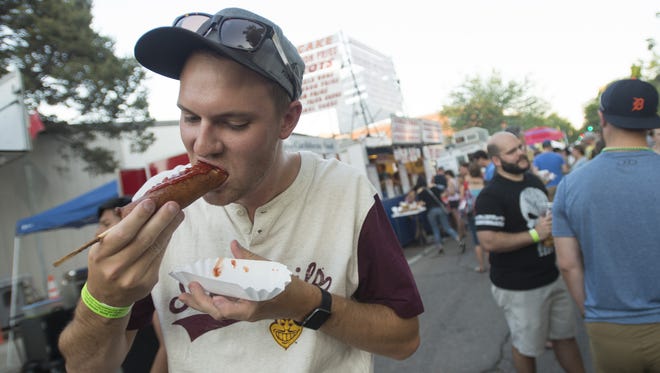 Austin Humphreys/The Coloradoan
Jackson Giro takes a bite from his corn dog as he wanders the festival grounds at Taste of Fort Collins on Friday. The fun continues through Sunday.
Jackson Giro takes a bite from his corn dog as he wanders the festival grounds at Taste of Fort Collins on Friday, June 9, 2017. The fun continues with food vendors and live music Saturday and Sunday.