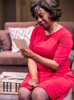 Stephanie Berry, as Katharine Gerard, ponders a photo of her late son in "Mothers and Sons" which runs through April 17 at the Playhouse.