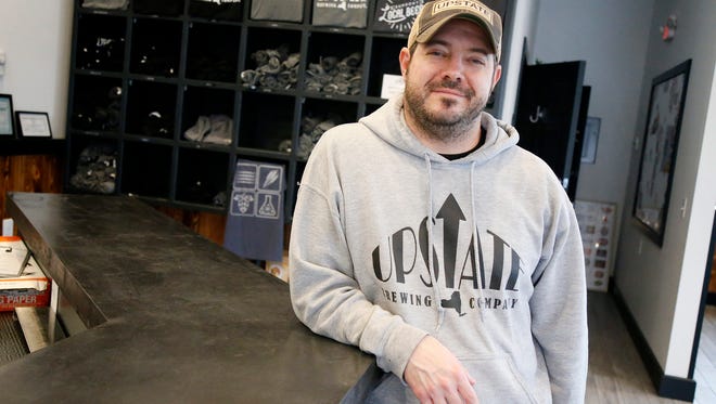 Mark Neumann, owner of Upstate Brewing Company, projects higher menu prices across the board at the business to help off-set a higher minimum wage. He poses inside the company's sit-in area on Jan. 26.