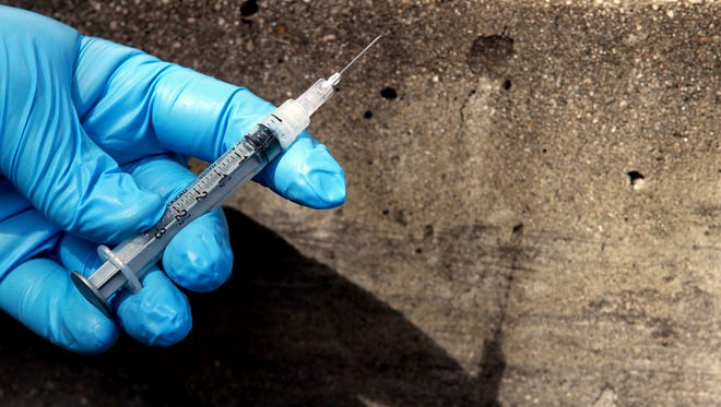 A syringe found next to a bench is a sign of the heroin epidemic.