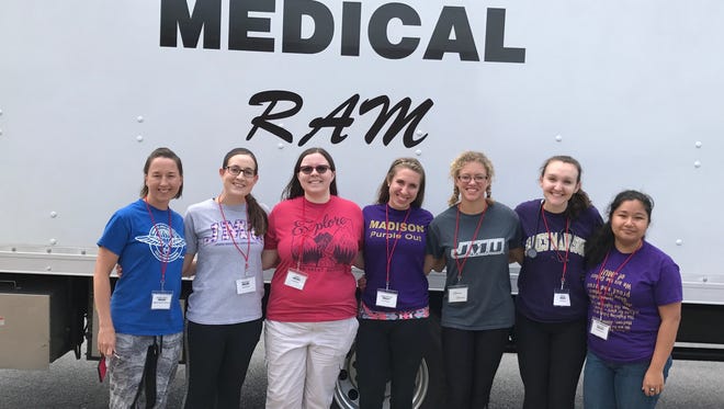 JMU Professor Laura Hunt Trull (left) stands beside her students while at a Remote Area Medical of Virginia clinic. Trull teaches Rural Health: An Interprofessional Approach and brings her students through a RAM for experience.