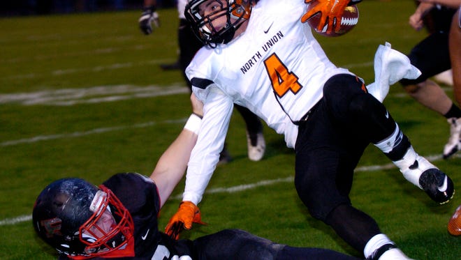 North Union Wildcat defensive back, Tim Davis, gets tripped up after an interception early in first-half varsity football action against the Spartans at Pleasant High School on Friday, October 2, 2015.