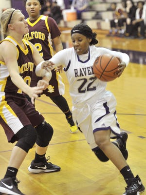 Anish Patterson of the Ravens tries to drive around Milford defender Brianna Cahall.