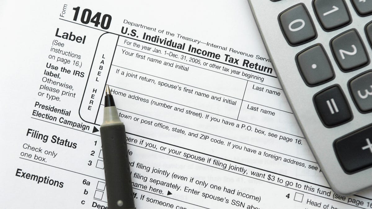 IRS form 1040 with a pen and calculator.