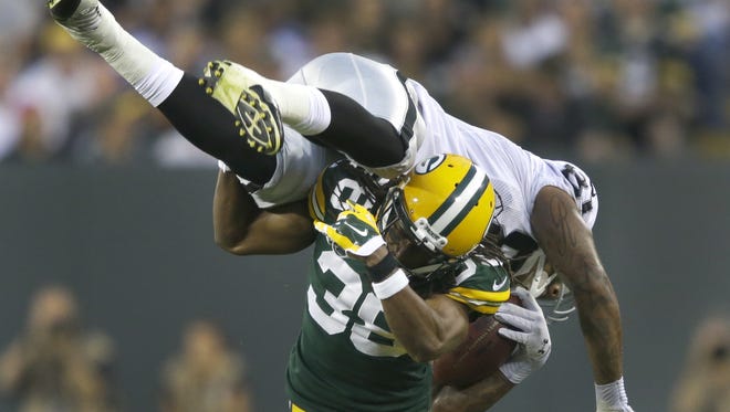 Green Bay Packers' Tramon Williams up ends Oakland Raiders' Mychal Rivera forcing him to drop the ball in the second quarter.
The Green Bay Packers host the Oakland Raiders Friday, August 22, 2014, at Lambeau Field in Green Bay, Wis.
Dan Powers/Post-Crescent Media