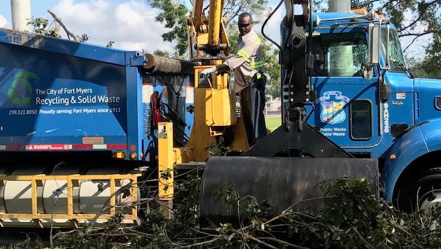 Julio Louis works the claw on a Fort Myers Public Works recycling and solid waste department truck along Edison Avenue. Louis was collecting vegetative debris left by Hurricane Irma.
