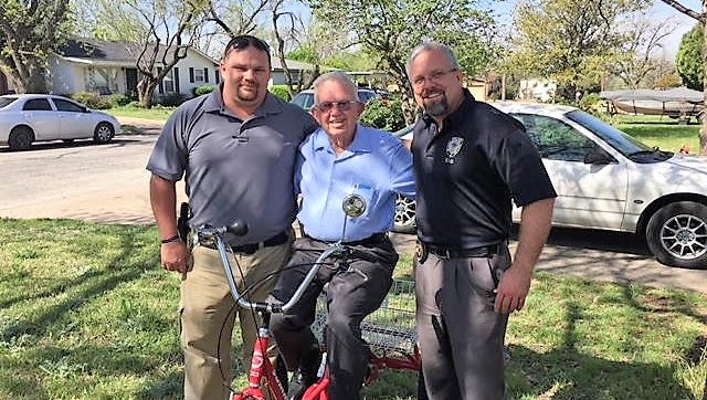 Ross Blassingame, center, is pictured with Abilene police detectives Carye Adkins, left, and Sgt. Jason Haak after they returned his stolen three-wheel bicycle on Friday.