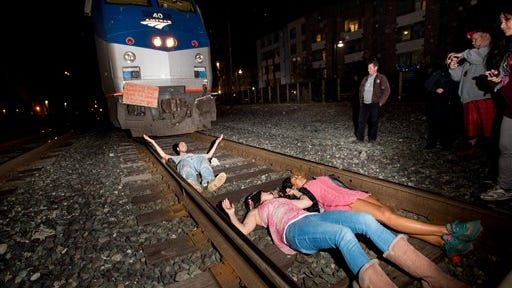 Protesters block an Amtrak train in Berkeley, Calif., on Monday, Dec. 8, 2014. Hundreds of people marched through Berkeley for a third night, blocking an interstate highway and stopping the train as activists rallied against grand jury decisions not to indict white police officers in the deaths of two unarmed black men. (AP Photo/Noah Berger)