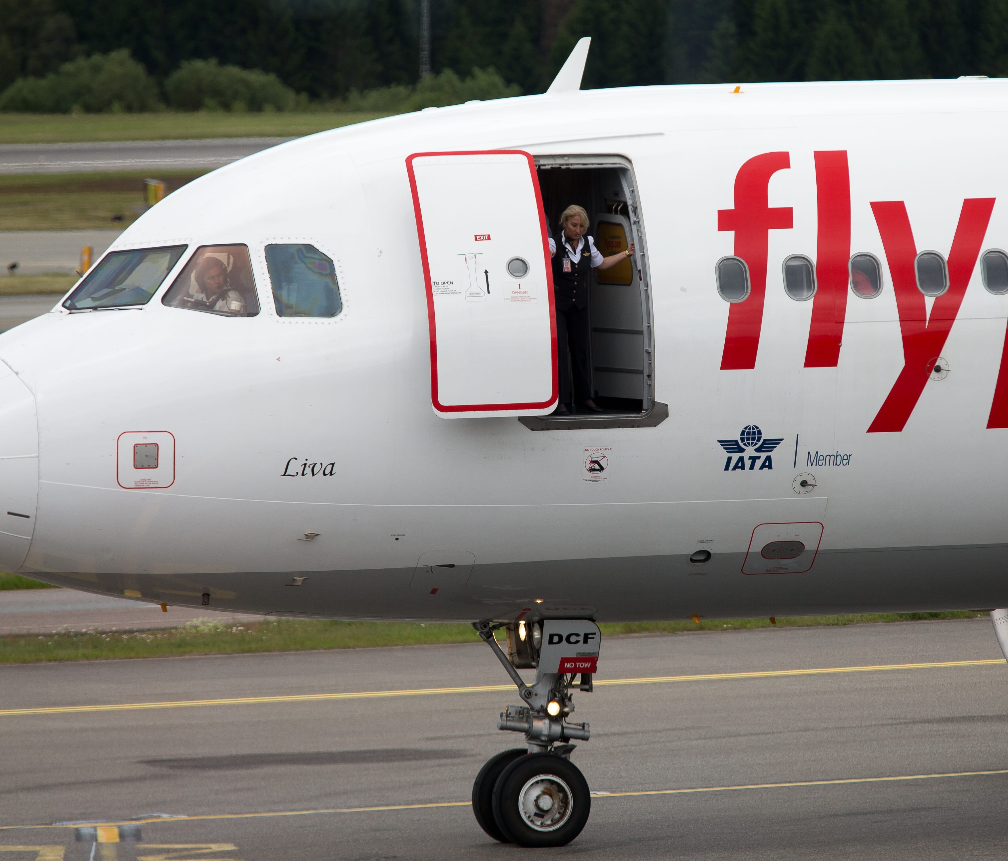 A flight attendant looks out an open door on a Pegasus Air plane on the taxiway at Stockholm Arlanda Airport on July 1, 2017.
