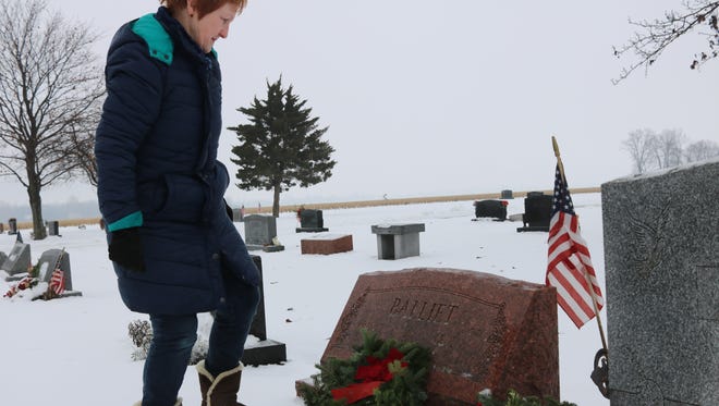 Beverly Haar, Harris Township trustee, places a wreath at her father Gene Balliet's grave as part of Wreaths Across America at Harris-Elmore Union Cemetery on Saturday.