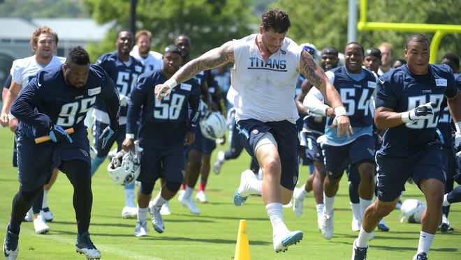 Titans defensive end Angelo Blackson (95) and left tackle Taylor Lewan, center, run a relay race at minicamp Thursday. They and their teammates completed the lap in 45 seconds.