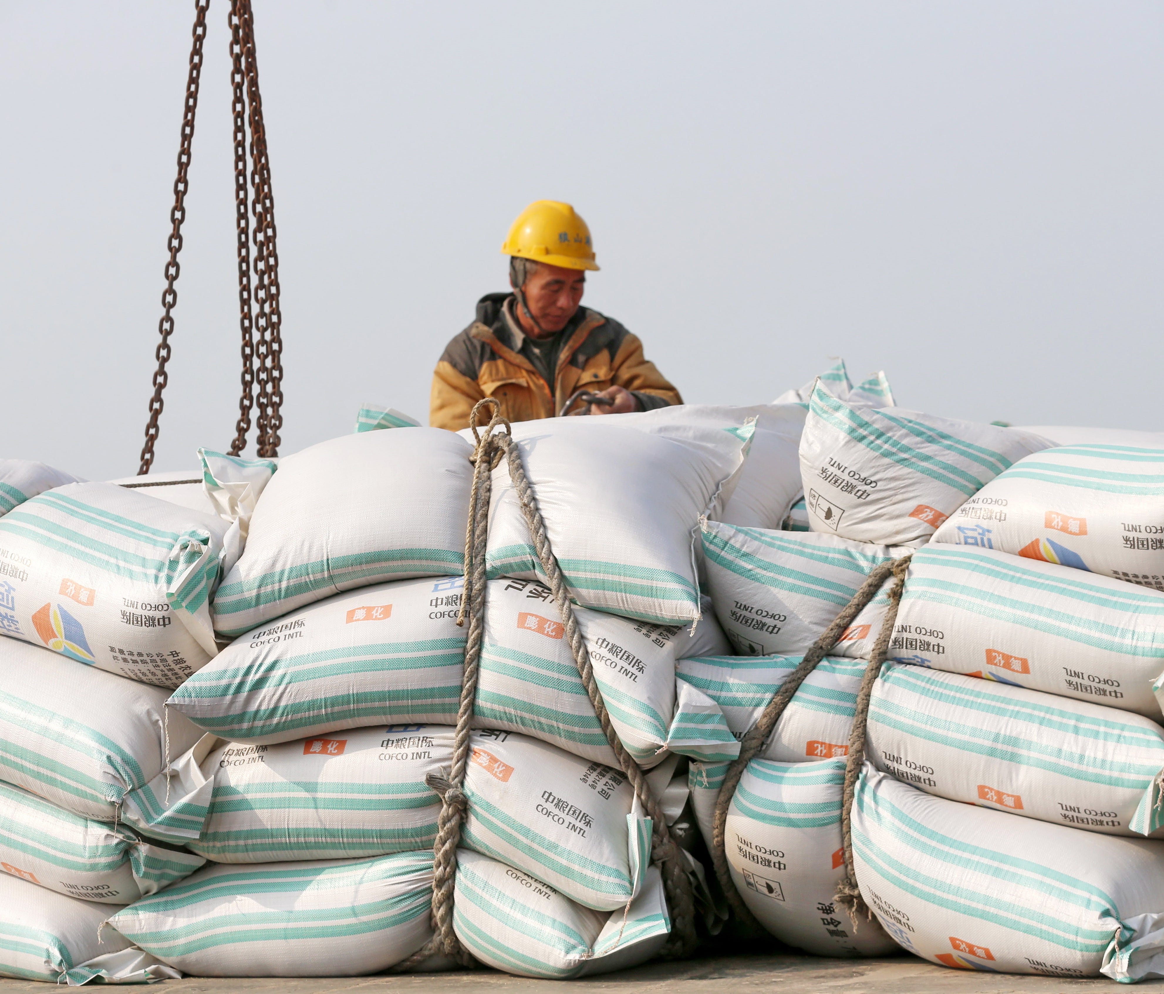A worker moves bags of soybean meal at a port in Nantong, Jiangsu province, China, 22 March 2018 (issued 04 April 2018). China will place 25 percent tariffs on a list of 106 US goods, in a retaliatory action against the US's new tariff on Chinese pro