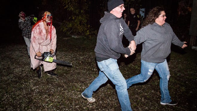 Visitors are chased out of the Scarevania haunted house by chainsaw wielding clowns in 2016.