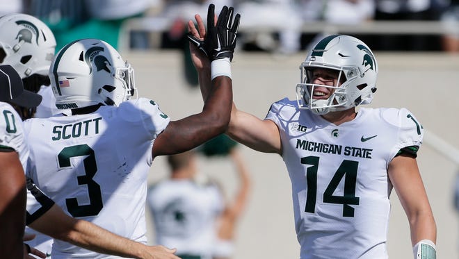 Michigan State quarterback Brian Lewerke (14) celebrates with running back LJ Scott after scoring on a 61-yard run against Western Michigan during the first half at Spartan Stadium on Sept. 9, 2017.