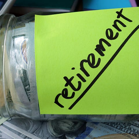 Jar with label Retirement Plan and money on the...