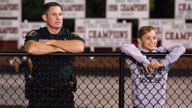 Martin County Sheriff's Office School Resource Deputy Dale Hardy, who is assigned to South Fork High School, and Connor Critoph, 12, of Indiantown, watch South Fork take on Olympic Heights during the high school girls soccer regional quarterfinal game Tuesday, Feb. 6, 2018, at South Fork High School in Tropical Farms.