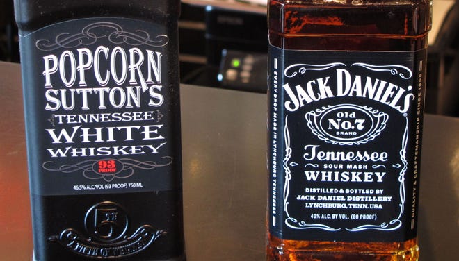 Bottles of Popcorn Sutton’s Tennessee White Whiskey and Jack Daniel’s Tennessee whiskey sit side by side at a Louisville, Ky., liquor store.