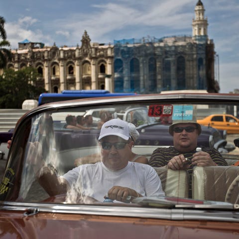 Tourists sit in a classic American car in Old Hava