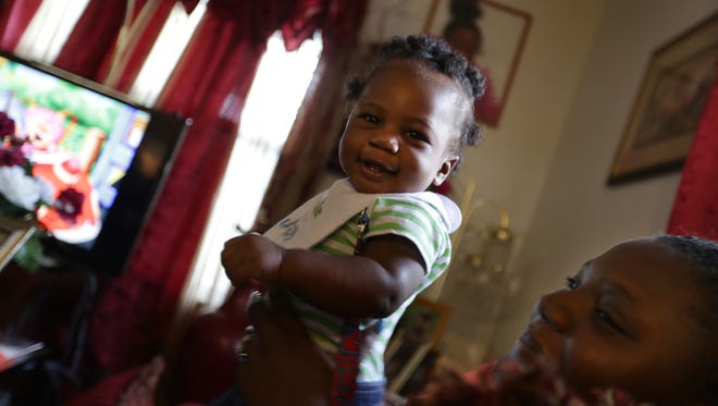 Brittany Addison, 22, right holds her son Kaiden Cotton, 7-months-old, while talking with nurse Jennifer Turner, left during a home visit from the Nurse- Family Partnership in Darlington, South Carolina in June 2016.