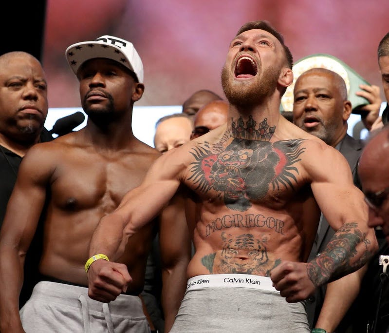 Conor McGregor screams after the faceoff with Floyd Mayweather Jr. during their official weigh-in at T-Mobile Arena.