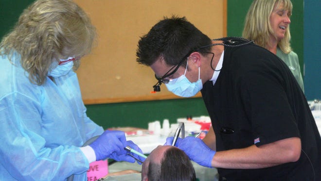 A patient receives dental work Saturday at the Remote Area Medical (RAM) walk-up clinic at the Boys & Girls Club of Mason Valley in Yerington.