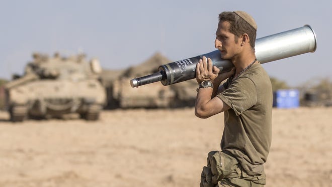 An Israeli soldier carries a shell near the border between Israel and the Gaza Strip on July 31, 2014.