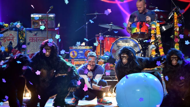 Singer Chris Martin (C) and musicians (L-R) Jonny Buckland, Will Champion and Guy Berryman of Coldplay perform onstage during the 2015 American Music Awards at Microsoft Theater on November 22, 2015 in Los Angeles, California.